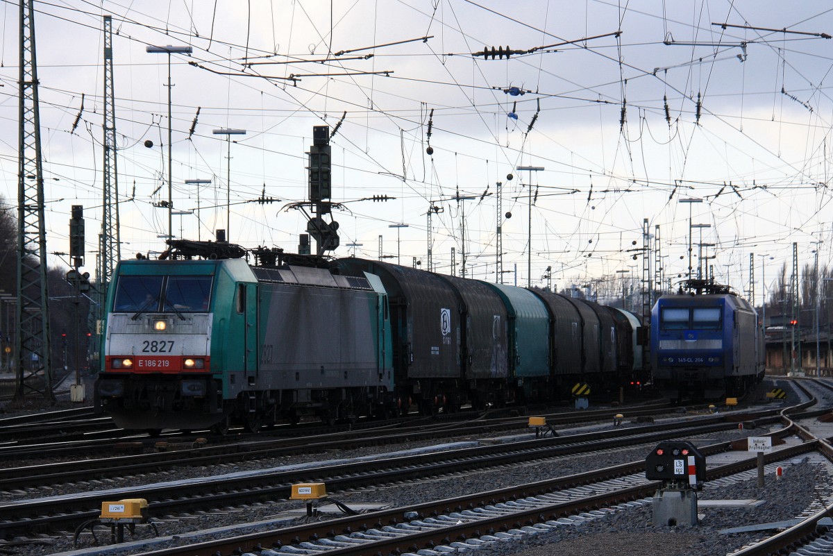 Die Cobra 2827 fährt mit einem langen gemischten Güterzug aus Köln-Gremberg nach Antwerpen-Noord(B) bei der Ausfahrt aus Aachen-West und fährt in Richtung Montzen/Belgien und auf dem Nebengleis eine 145 CL-204 von Crossrail steht mit 8 E-Loks von Crossrail stehen auf dem Abstellgleis in Aachen-West bei Sonne und Regenwolken am Nachmittag vom 16.2.2014. 