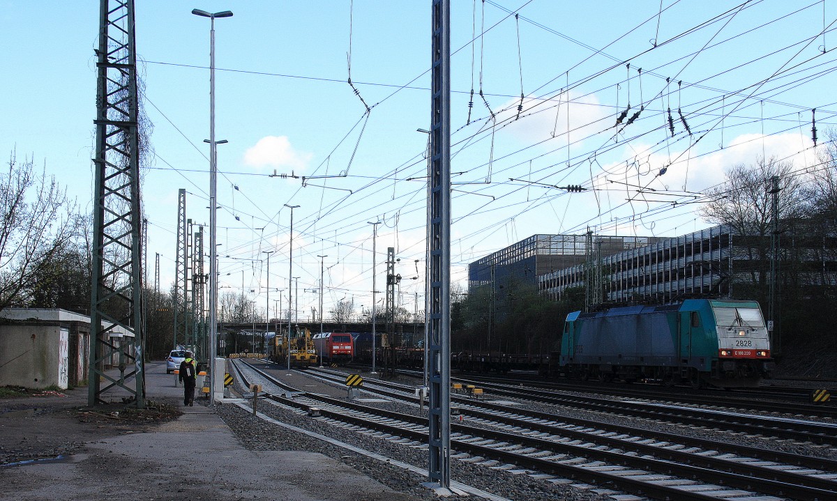 Die Cobra 2828 kommt aus Richtung Köln,Aachen-Hbf mit einem Kurzen gemischten Güterzug aus Köln-Gremberg nach Antwerpen-Noord(B) und fährt in Aachen-West ein und im Hintergrund rangiert die 152 056-8 DB Aufgenommen in Aachen-West bei Sonne und Regenwolken am Nachmittag vom 23.3.2014.
