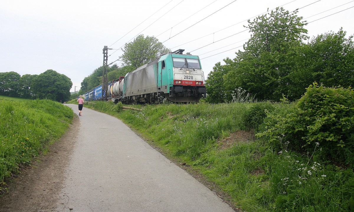 Die Cobra 2828  kommt die Gemmenicher-Rampe herunter nach Aachen-West mit einem  langen Containerzug aus Antwerpen-BASF(B) nach Gallarate(I). Aufgenommen an der Montzenroute am Gemmenicher-Weg. 
Bei Regenwolken am 16.5.2015.
