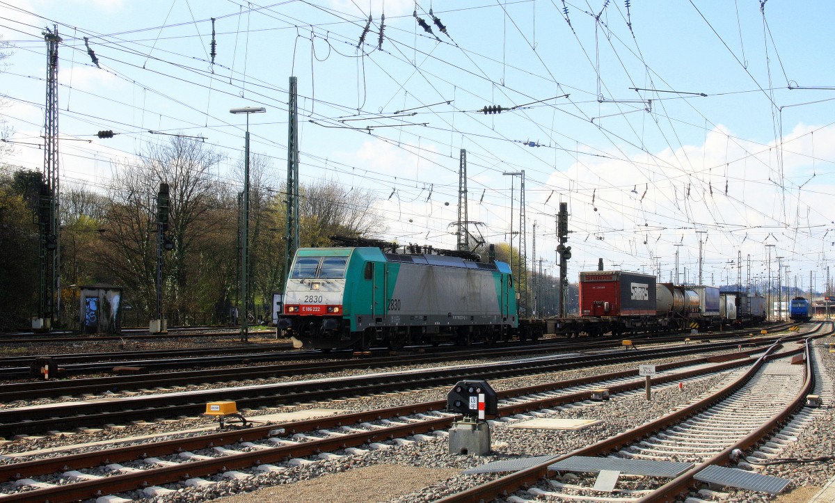 Die Cobra 2830 fährt mit einem langen Containerzug aus Gallarate(I) nach Antwerpen-Oorderen(B) bei der Ausfahrt aus Aachen-West und fährt in Richtung Montzen/Belgien und im Hintergrund  steht eine 185 535-2 von Crossrail und Zwei 185er von Crossrail stehen auf dem Abstellgleis in Aachen-West bei Sonne und Regenwolken am 23.3.2014. 