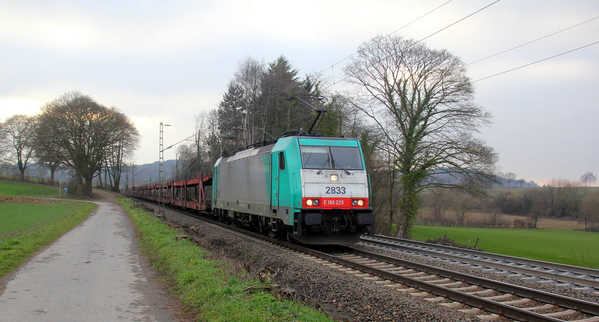 Die Cobra 2833  kommt die Gemmenicher-Rampe herunter nach Aachen-West mit einem langen Autoleerzug aus Belgien nach Aachen-West(D) und fährt in Richtung Aachen-West. 
Aufgenommen an der Montzenroute am Gemmenicher-Weg.
Bei Sonne und Regenwolken am Nachmittag vom 22.2.2019.