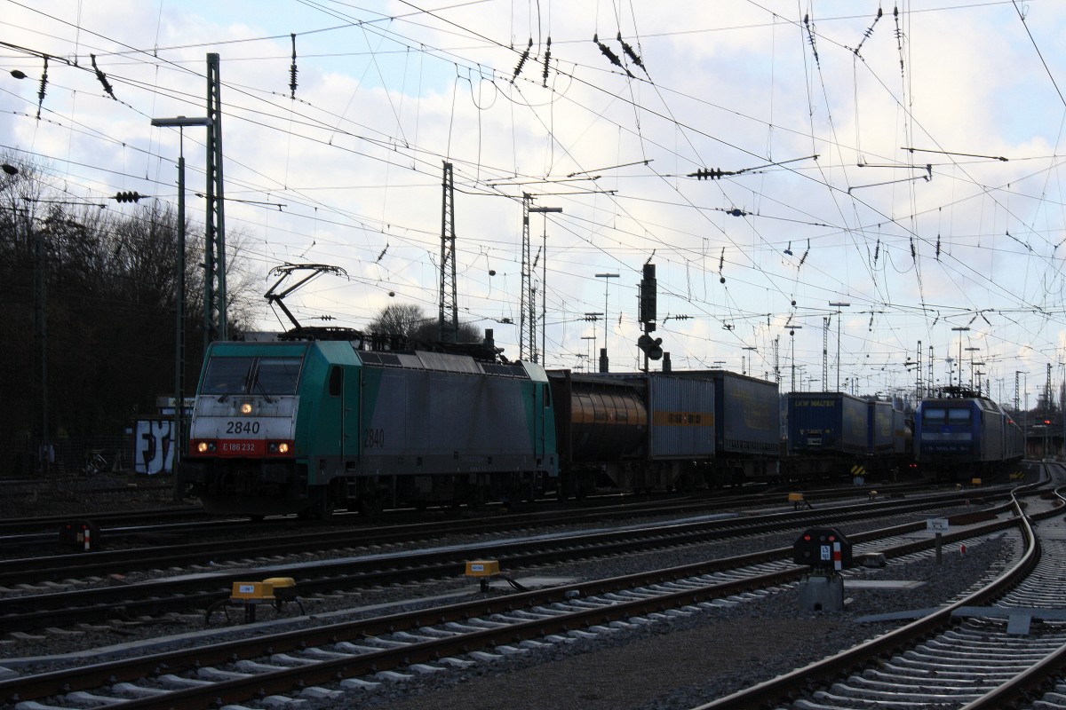 Die Cobra 2840 fährt mit einem langen Containerzug aus Verona(I) nach Antwerpen-Noord(B) bei der Ausfahrt in Aachen-West und fährt in Richtung Montzen/Belgien 
und auf dem Nebengleis eine 145 CL-204 von Crossrail steht mit 8 E-Loks von Crossrail stehen auf dem abstellgleis in Aachen-West bei Sonne und Regenwolken am Nachmittag vom 16.2.2014. 