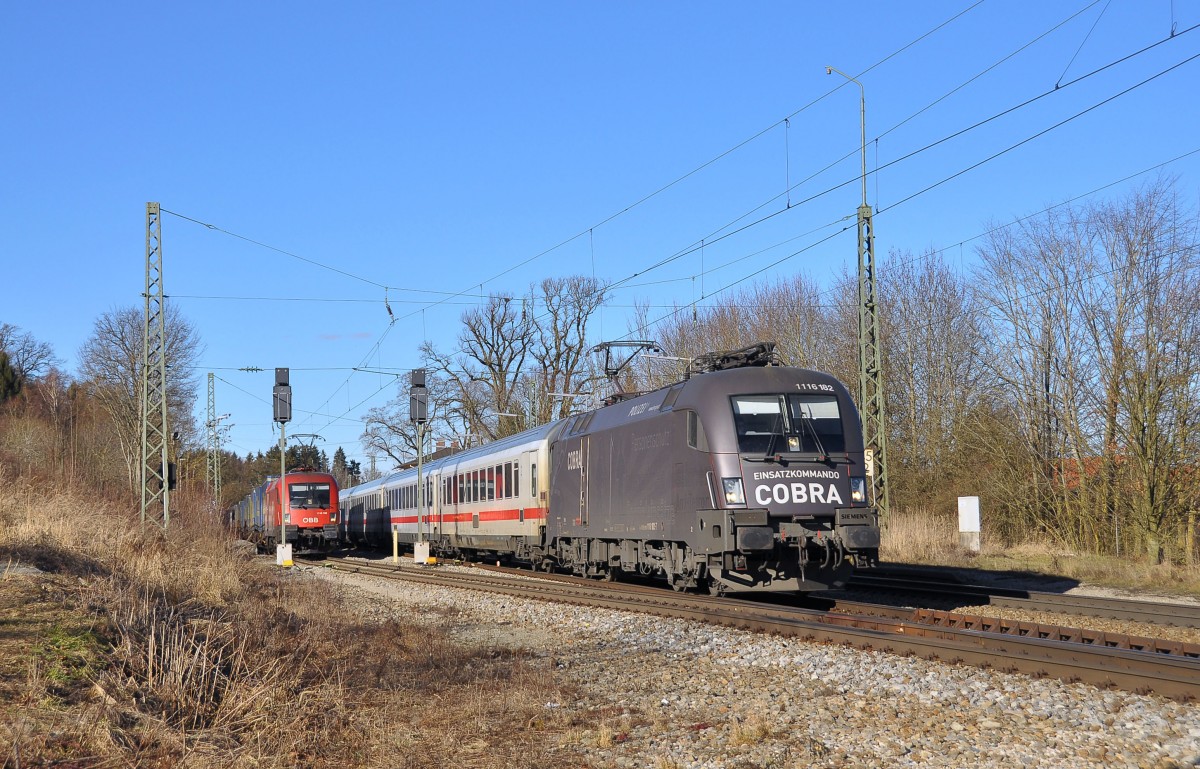 Die Cobra Lok 1116 182 fährt mit dem IC 2083 von Hamburg nach Berchtesgaden.Im Hintergrund wartet ihre Schwesterlok mit dem LKW-Walter auf die weiterfahrt.Bild entstand in Aßling Obb.am 6.2.2014