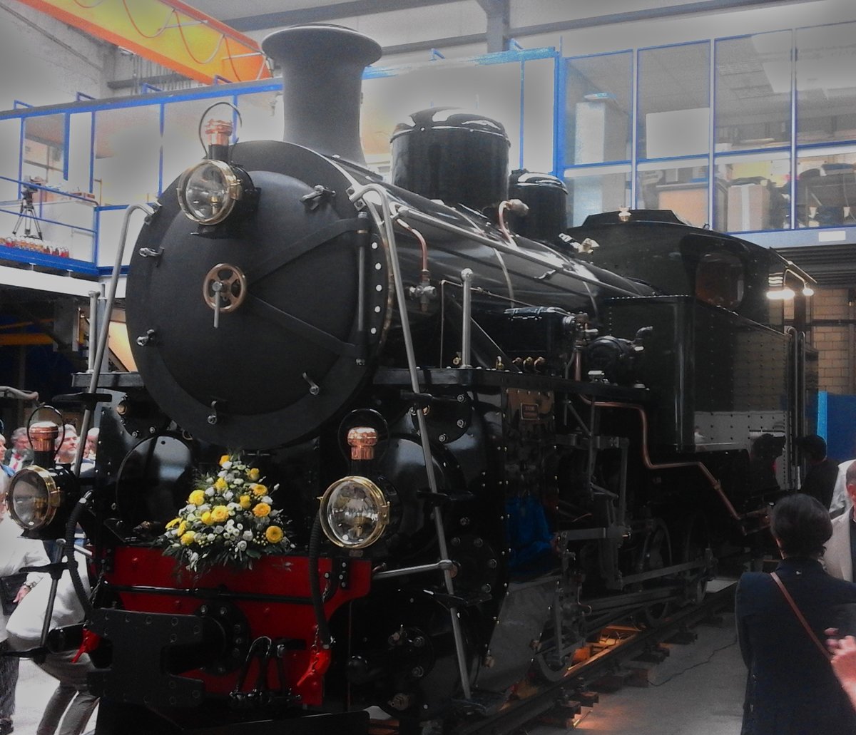 Die Dampfbahn Furka Bergstrecke (DFB) öffnete Am Wochenende vom 16. und 17. Juni 2018 die Tore zu ihrer Werkstätte in Uzwil. Unter anderem war der Anlass dazu gedacht, ihre neuste Lokomotive vorzustellen, die frisch restaurierte HG 4/4 704. Sie soll diesen Sommer auf der Bergstrecke eingesetzt werden.

Hier auf dem Bild präsentiert sie sich ihren Besuchern in der Werkhalle.

Die HG 4/4 704 wurde 1923 als Nummer 2940 von der Schweizerischen Lokomotiv- und Maschinenfabrik in Winterthur für den Vietnam gebaut. Zwischen 1923 und 1990 wurde sie im Vietnam eingesetzt und später dann remisiert, bevor sie 1990 vom DFB in die Schweiz zurückgeholt wurde. Zwischen 2003 und 2018 wurde sie in Chur und Uzwil durch den DFB in 48'000 Arbeitsstunden revidiert.

Uzwil, 17.06.2018