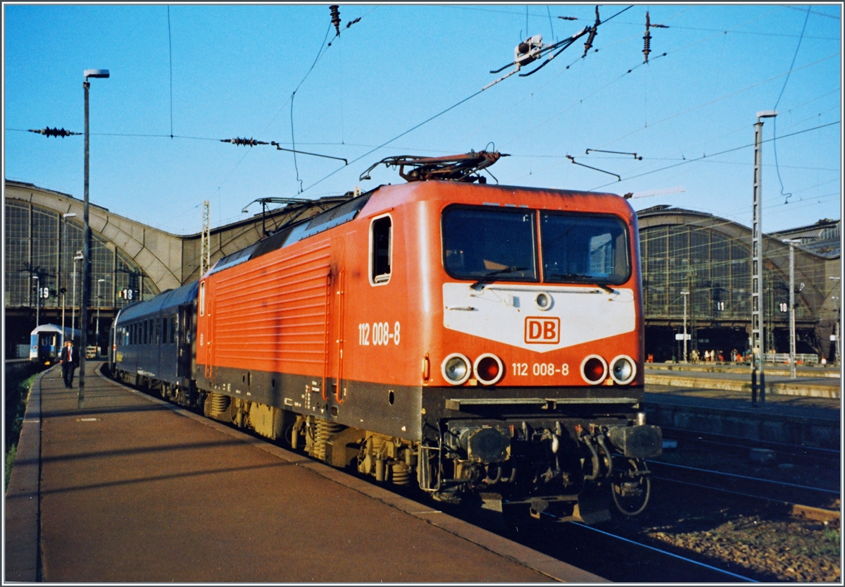 Die DB 112 008-8 mit einem Nachtzug nach Dresden mit CNL Kurswagen von Zürich gleich hinter der Lok kurz vor der Abfahrt in Leipzig. 

Analogbild vom 29. August 1996