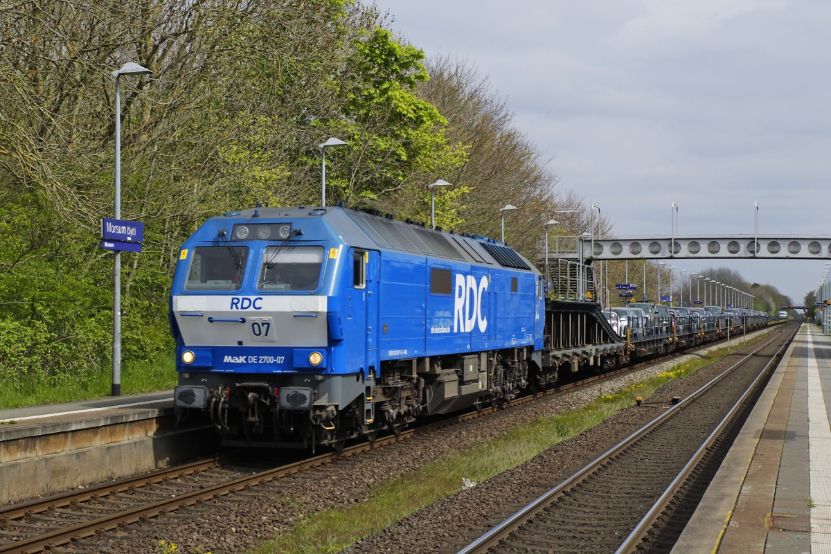 Die DE 2700-07 von RDC befördert am 04.05.2023 einen Autozug durch den Bahnhof Morsum nach Westerland