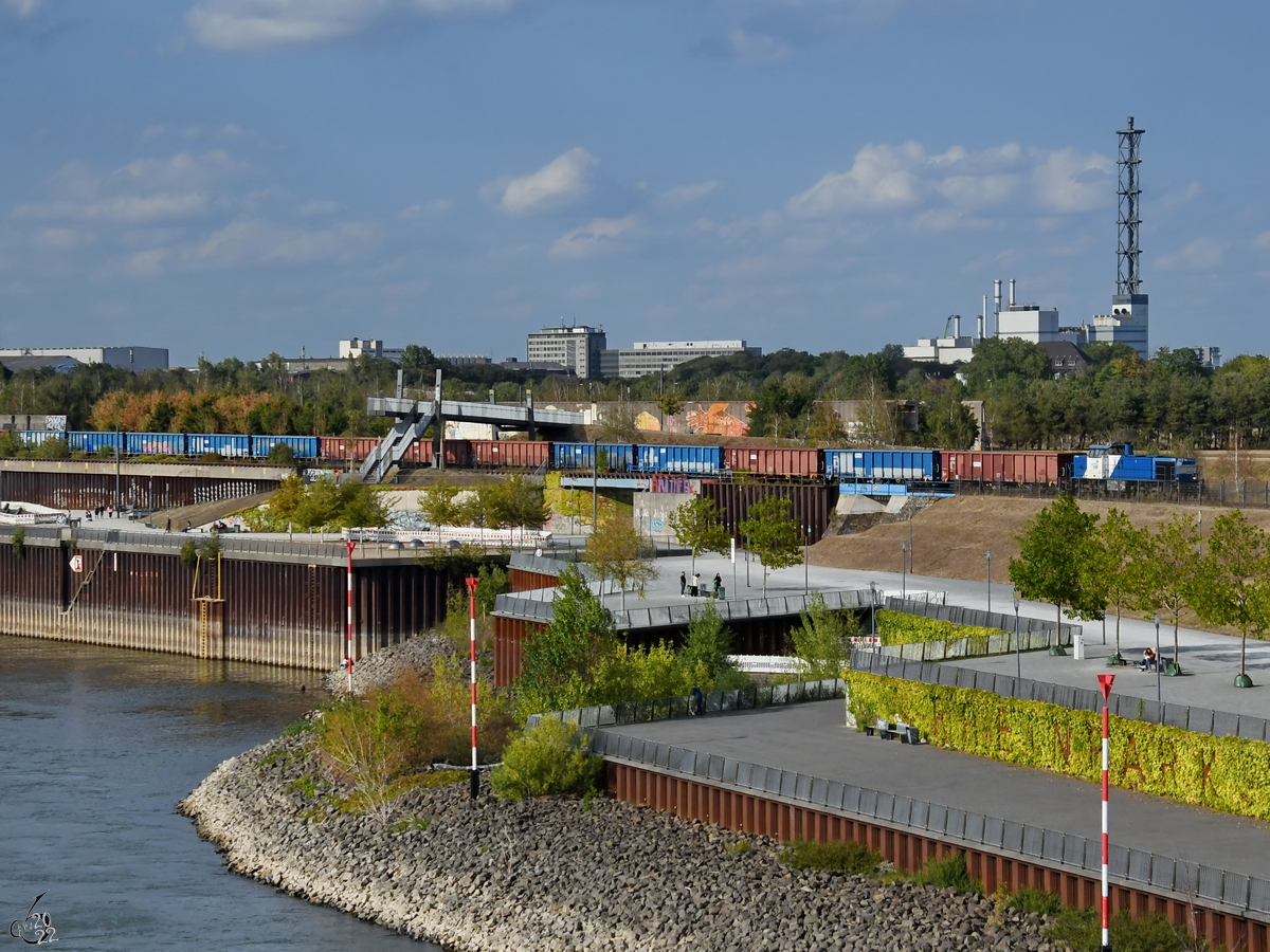 Die Diesellokomotive 1275 635-1 schiebt einige Leerwagen durch den Rheinpark. (Duisburg, August 2022)