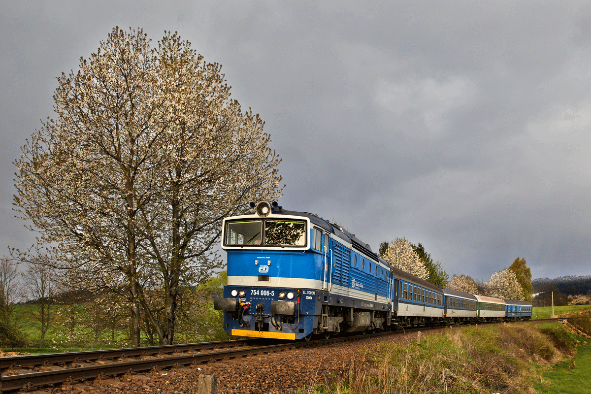 Die Diesellokomotive 754 006-5 fährt mit einem Os bei Aprilwetter in Nyrsko vorüber.Bild vom 19.4.2017