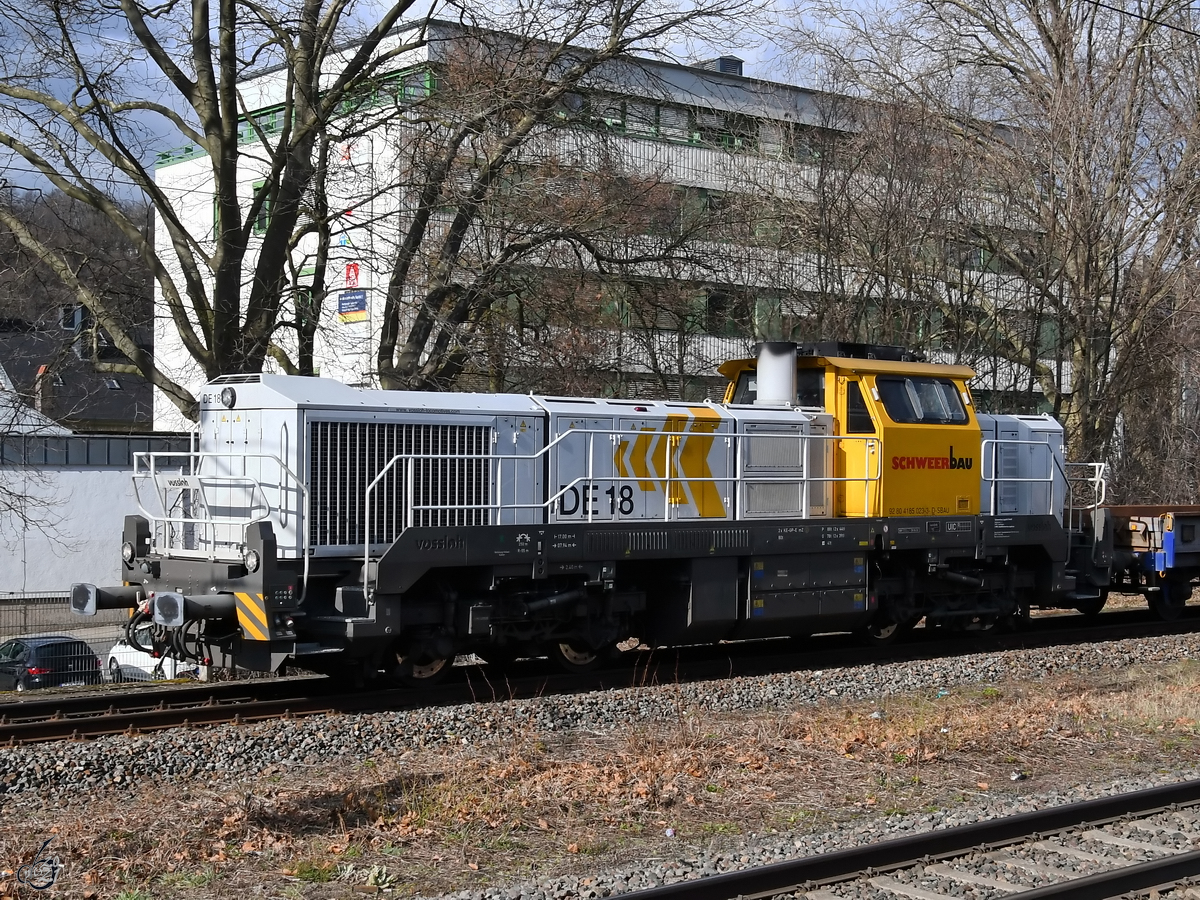 Die Diesellokomotive DE18 zieht einen Bauzug durch Wuppertal-Unterbarmen. (März 2021)