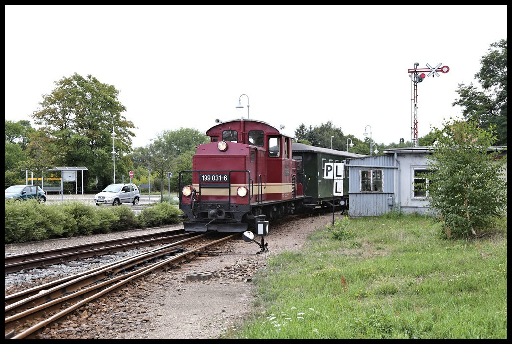 Die Döllnitzbahn fährt hier mit Zug 103 aus Mügeln kommend am 5.8.2023 um 10.32 Uhr in Oschatz ein.Zuglok 199031-6 passiert dabei das heute still gelegte Stellwerk Häuschen. Die Signale werden nicht mehr gestellt. Die Weichen stellt man von Hand.