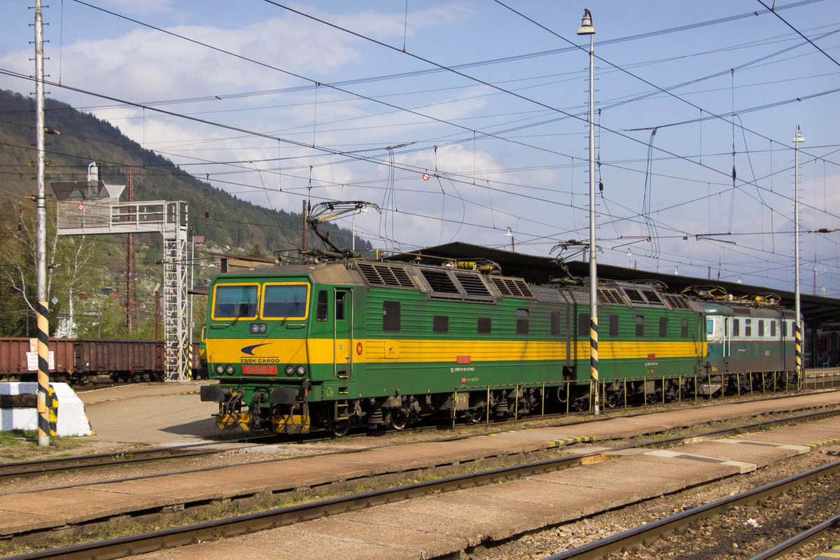 Die Doppelloks sind kaum auf ein Bild zu kriegen, ohne das nicht mindestens ein Oberleitungsmast im Weg steht. Oder wie hier eben eine Lampe...
131 045-7 + 131 046-5 durchfahren den Bahnhof Zilina am 24. April 2019. Im Schlepp ist noch die 183 008-2 zu sehen. 
