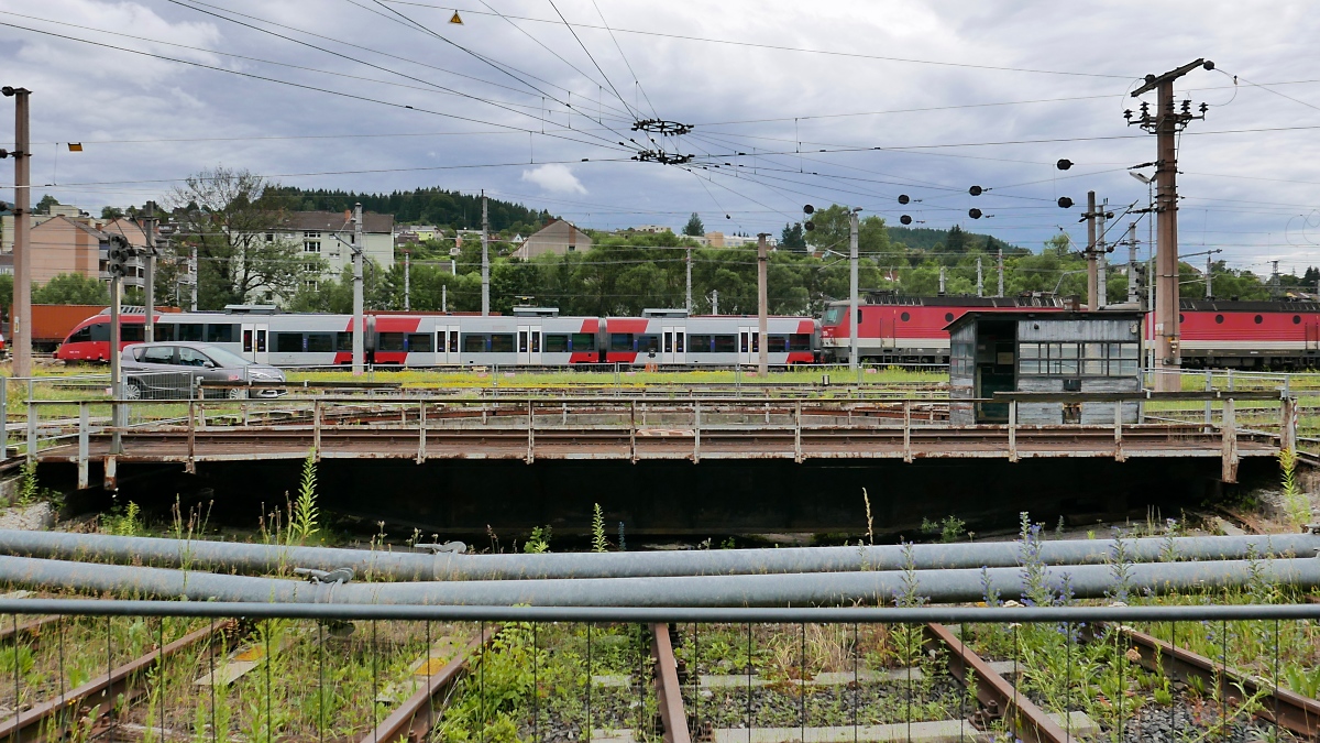 Die Drehscheibe vor dem Rundlokschuppen des Südbahnmuseums am Bahnhof Mürzzuschlag, 07.07.2019 

Zum Lokschuppen hin wurden Heizungsrohre quer über die Anschlussgleise montiert.