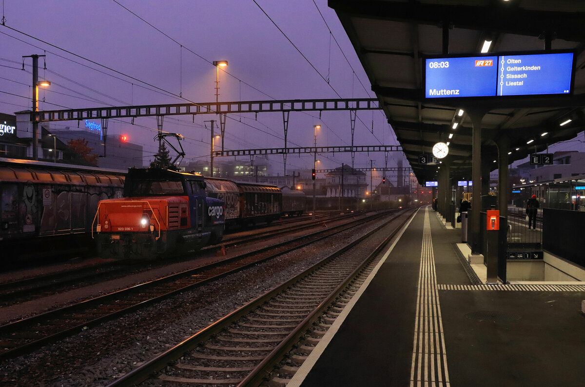 Die Eem 923 006 an einem nebligen Morgen in Zofingen. Die rötlich-violette Farbe des Himmels ergibt sich aus dem grellen Morgenrot über der dichten Nebeldecke. Angezeigt ist ein IR mit ungewöhnlichem Ziel nur bis Muttenz statt Basel. 30.Oktober 2021 