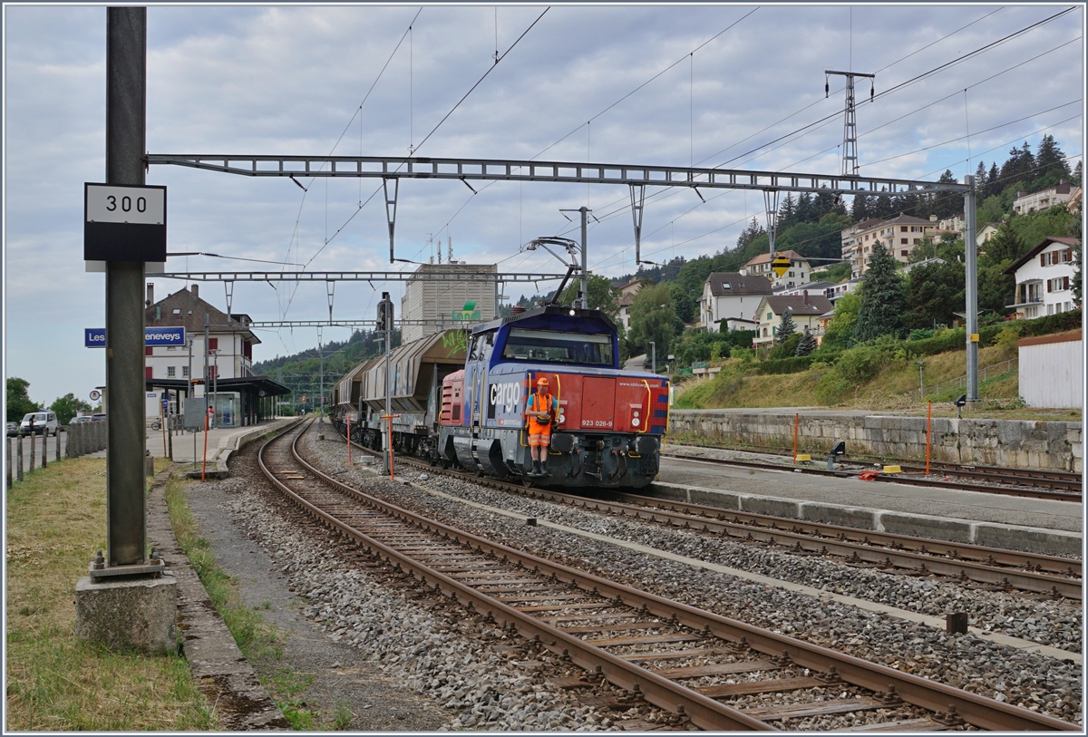 Die Eem 923 026-9  Hofberg  beim Manöver der Tagnpps in Les Hauts-Geneveys: drei Wagen werden zur Beladung bei der Landi (Gleis 4) verschoben, während drei weitere in der Zwischenzeit auf Gleis drei abgestellt werden. 

Das Neigeschild links im Bild zeigt, wie sparsam beim Bau der Strecke mit eben Abschnitten (in den Bahnhöfen) umgegangen wurde, um bei der Führung der Strecke mit einer Spitzkehre und 27 Promille Steigung doch den nötigen Höhenunterschied zu verschaffen. 

12. August 2020
