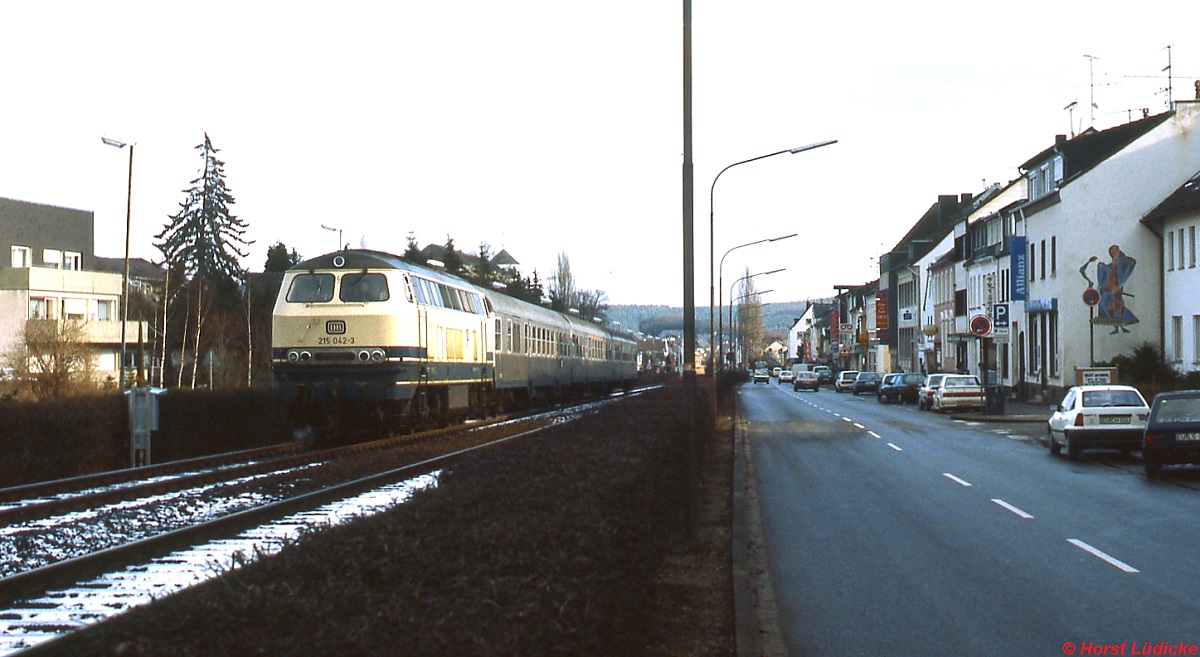 Die Eifelbahn führt mitten durch Mechernich, hier Ende der 1980er Jahre mit 215 042-3 vor einem Eilzug nach Trier
