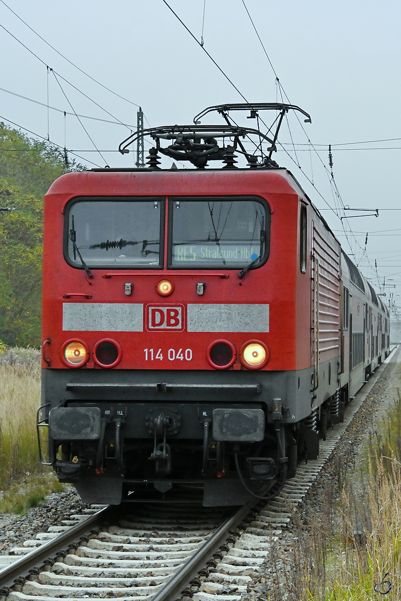 Die Elektrolokomotive 114 040 zieht RE5 nach Stralsund Hbf, hier bei der Einfahrt am Bahnhof Demmin. (November 2020)