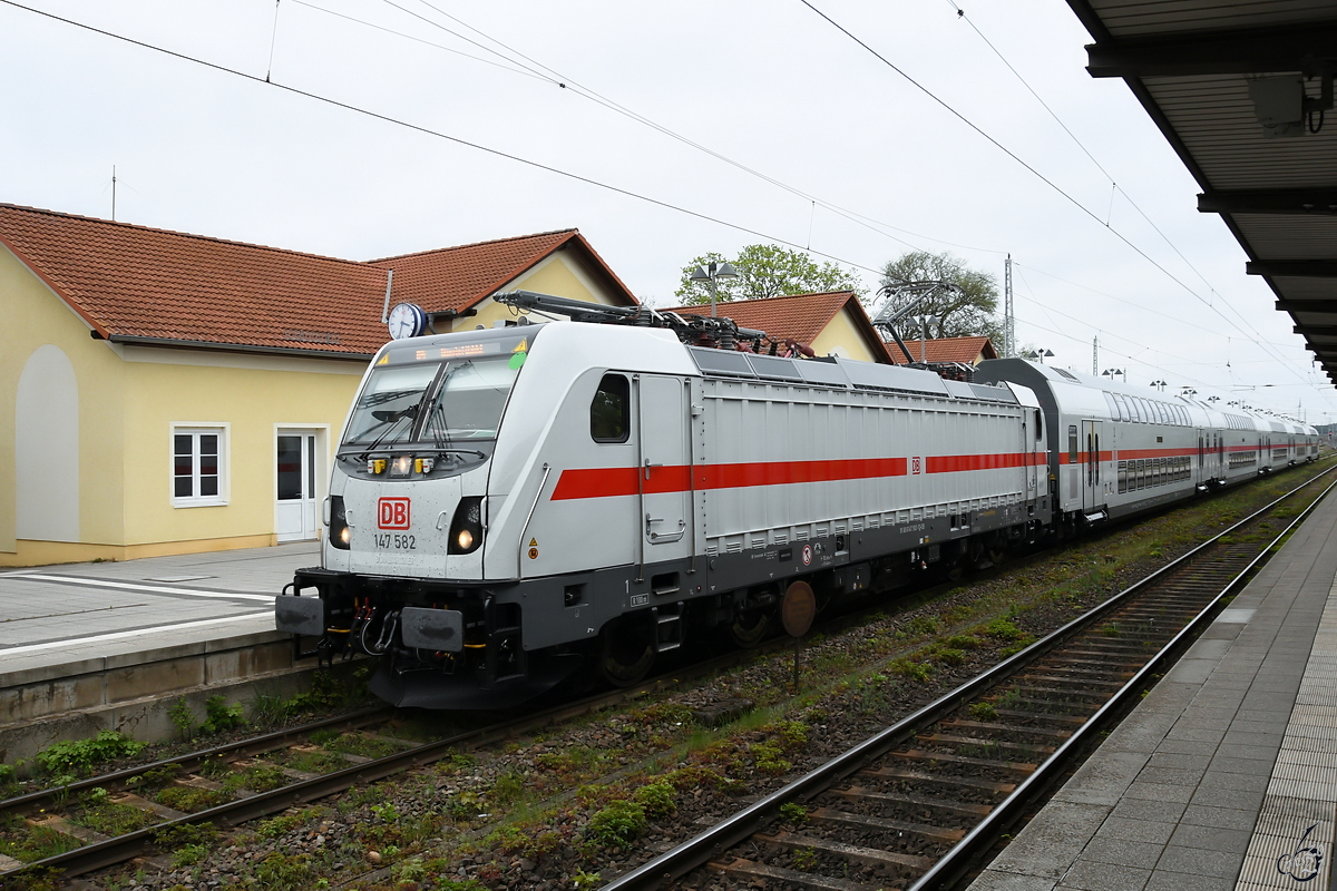 Die Elektrolokomotive 147 582 zieht eine IC2-Einheit, so gesehen Mitte Mai 2021 am Hauptbahnhof in Neustrelitz.