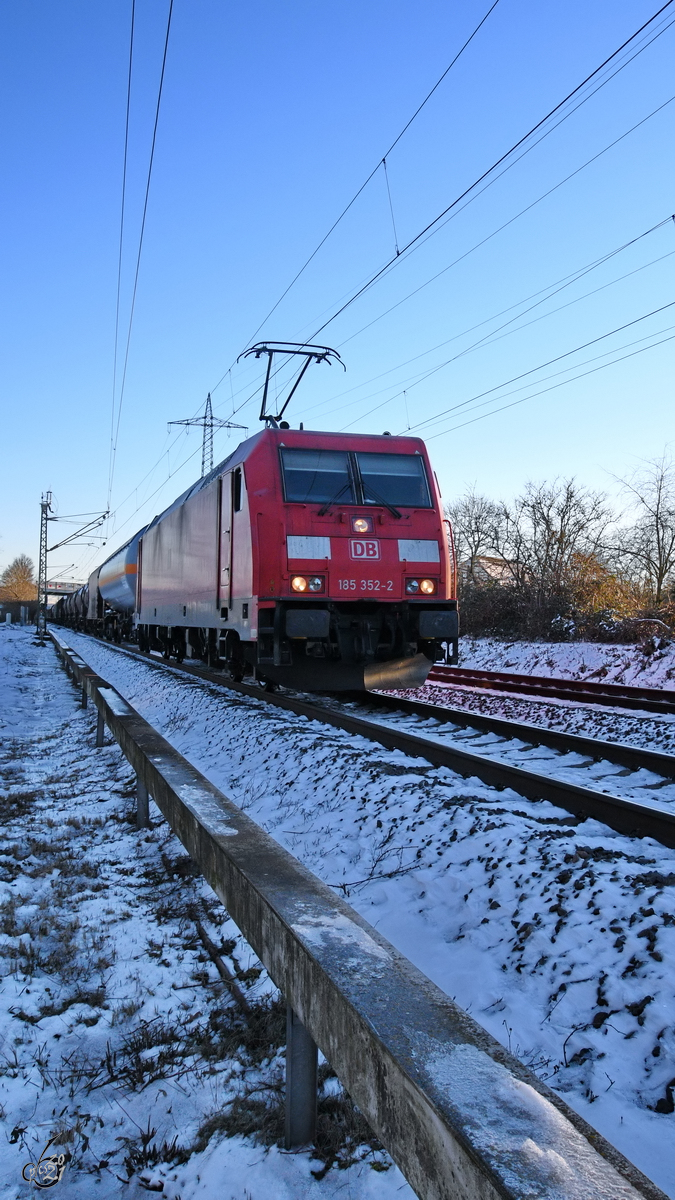 Die Elektrolokomotive 185 352-2 mit einem Güterzug, so gesehen im Februar 2021 in Lintorf.