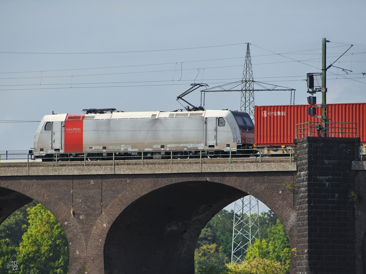 Die Elektrolokomotive 185 699-7 befährt die Hochfelder Eisenbahnbrücke, so gesehen Ende August 2022 in Duisburg.