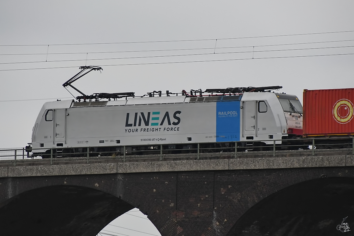 Die Elektrolokomotive 186 497-4 auf der Hochfelder Eisenbahnbrücke, so gesehen Ende August 2022 in Duisburg.