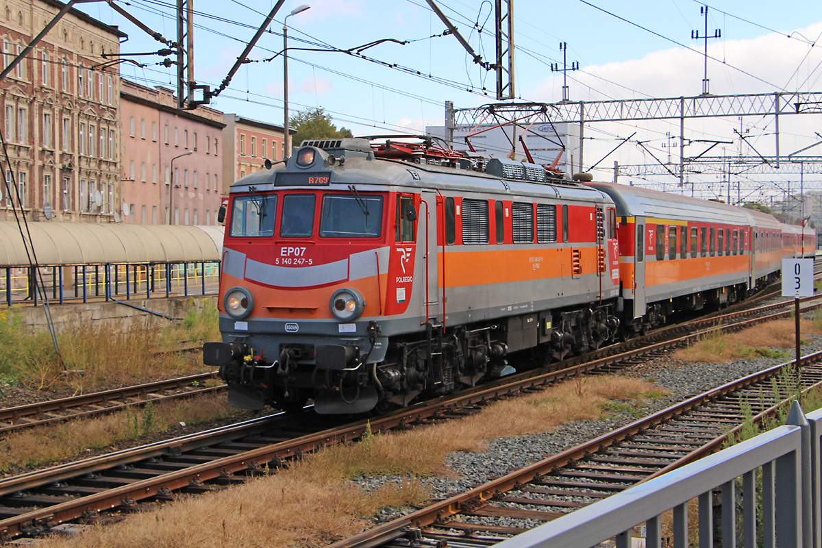 Die EP07P-2003 der Polregio, einer Tochtergesellschaft der PKP für den Regionalverkehr, verlässt mit ihrem R76901 am 02.10.2018
den Bahnhof Jelenia Gora für den letzten Abschnitt ihrer -für einen Regionalzug- langen Fahrt nach Szklarska Poręba Górna,
die Reise begann schon am frühen Morgen in Poznan Główny. Die Lokomotive wurde bei ZNLE Gliwice aus der EU07-189 modernisiert
und bildet mit der farbenfrohen Lackierung und den für Polen typischen großen Lampen eine interessante Abwechslung auf den
Gleisen unseres Nachbarn.