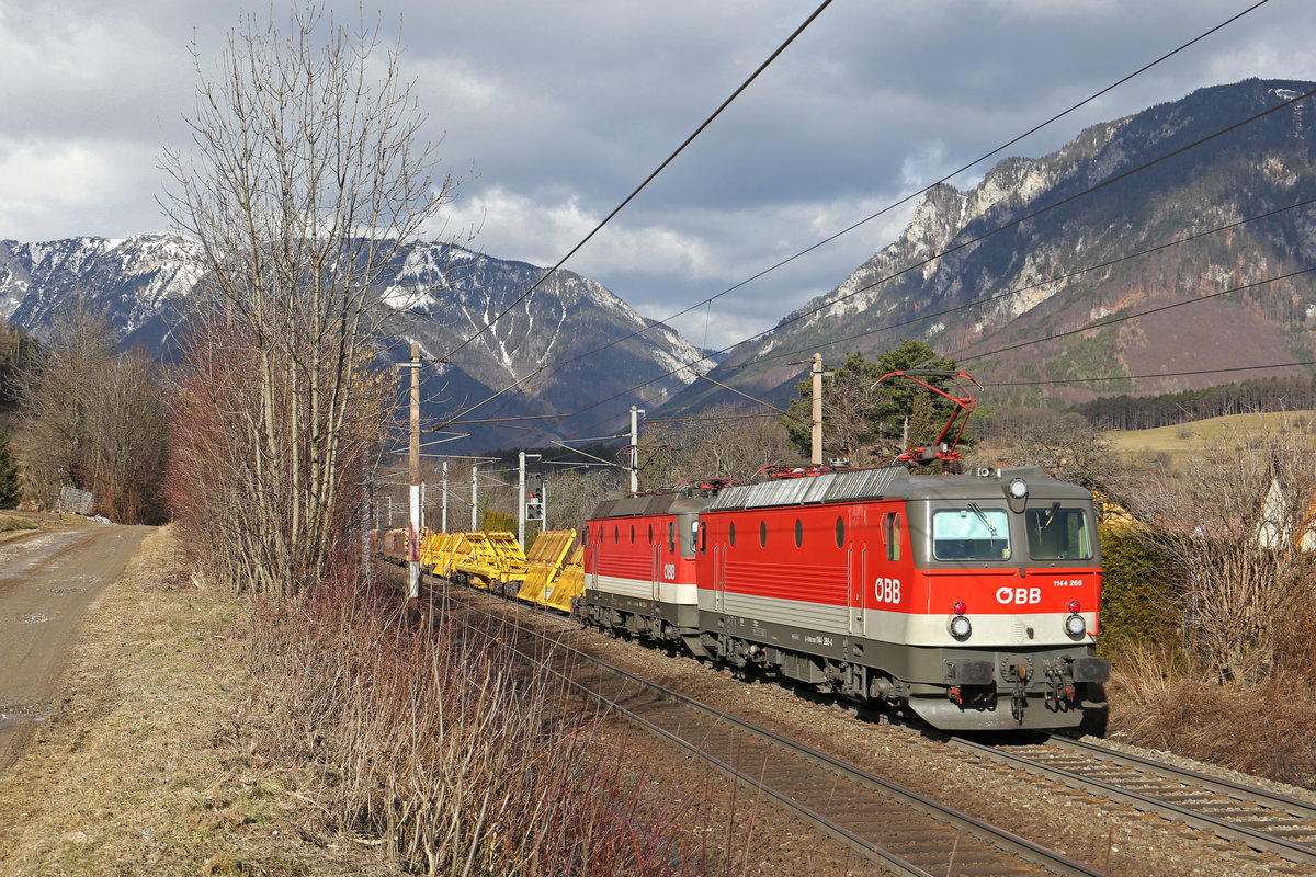 Die erst im November hauptausgebesserte 1144.266 fährt mit ihrer Schwester 251 am G-54627 bei Payerbach/R. mit links der Rax und rechts dem Saurüssel im Hintergrund und viel Sonnenglück am 25.2.17 bergwärts.Am Foto erkennt man deutlich den Farbunterschied am unteren Streifen zwischen Steingrau bei der letzten Serie von 256-290 und weiss bei 241-255