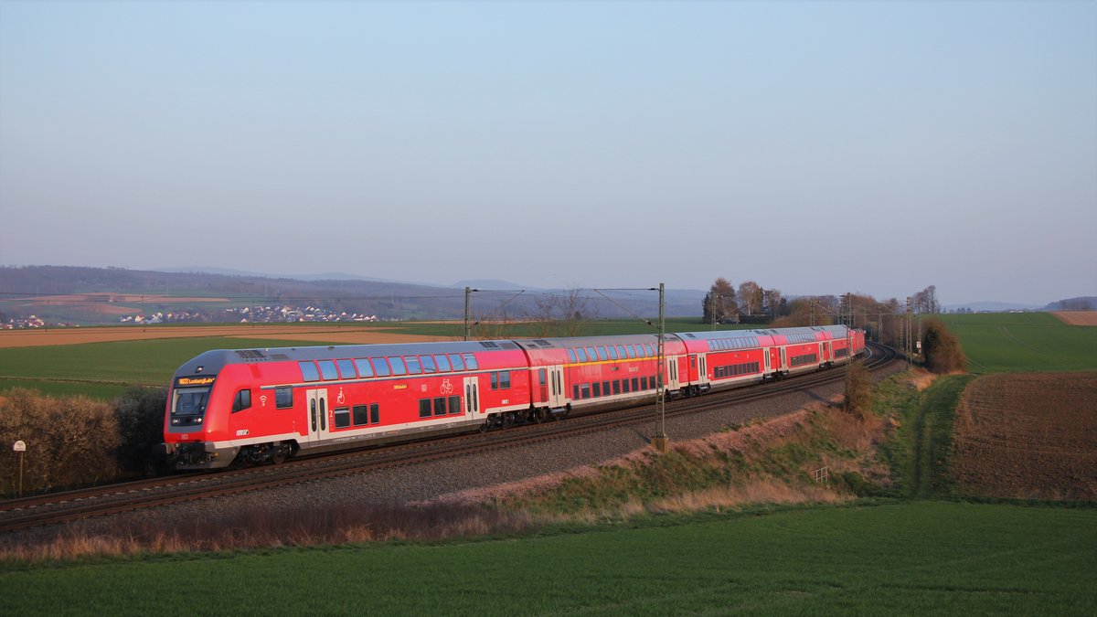 Die ersten modernisierten Doppelstockwagen für das Taunus-Netz fahren seit Anfang 2020 auf den Linien RE20 und RB22 zwischen Frankfurt(Main)Hbf und Limburg(Lahn). Hier fährt ein Zug als Regionalbahn, bestehend aus mod Steuerwagen, sowie drei verschiedenen Mittelwagen-Bauarten (an mittlerer Stelle noch ein modernisierter Mittelwagen, am späten Nachmittag des 27. März 2020 in den Bahnhof von Bad Camberg ein, nahe der Zugspitze steht die Rangierhalttafel.