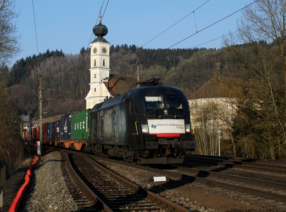 Die ES 64 U2-027 mit einem Containerzug am 27.02.2015 bei der Durchfahrt in Wernstein. 