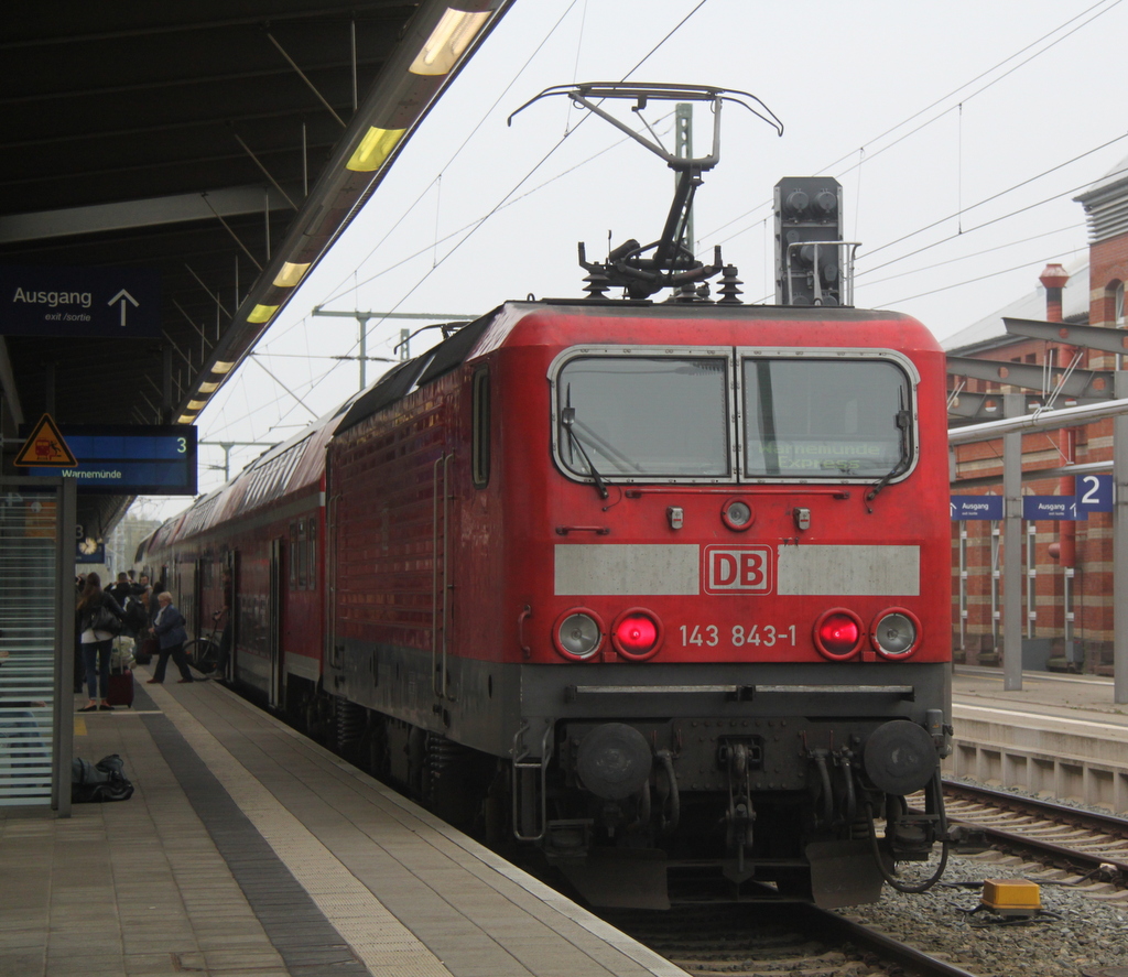 Die ex Rostocker 143 843-1 mit RE 18590 von Berlin Hbf(tief)nach Warnemnde beim Fahrgastwechsel im Rostocker Hbf.03.10.2014 