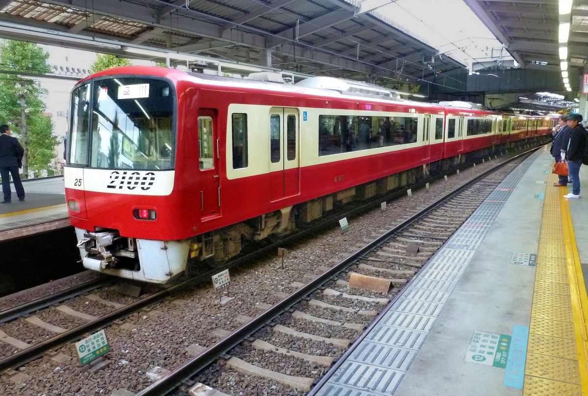 Die Fahrzeuge des Keihin Kyûkô-Konzerns, Serie 2100: Die 10 bequemen 8-Wagenzüge Serie 2100 mit nur zwei Eingängen pro Wagen für Reisen auf längeren Strecken vor allem in die neuen Wohnsiedlungen auf der Miura Halbinsel wurden 1998-2000 in Dienst gestellt. Im Bild Zug 2125 in Tokyo-Shinagawa, 25.Oktober 2011.   