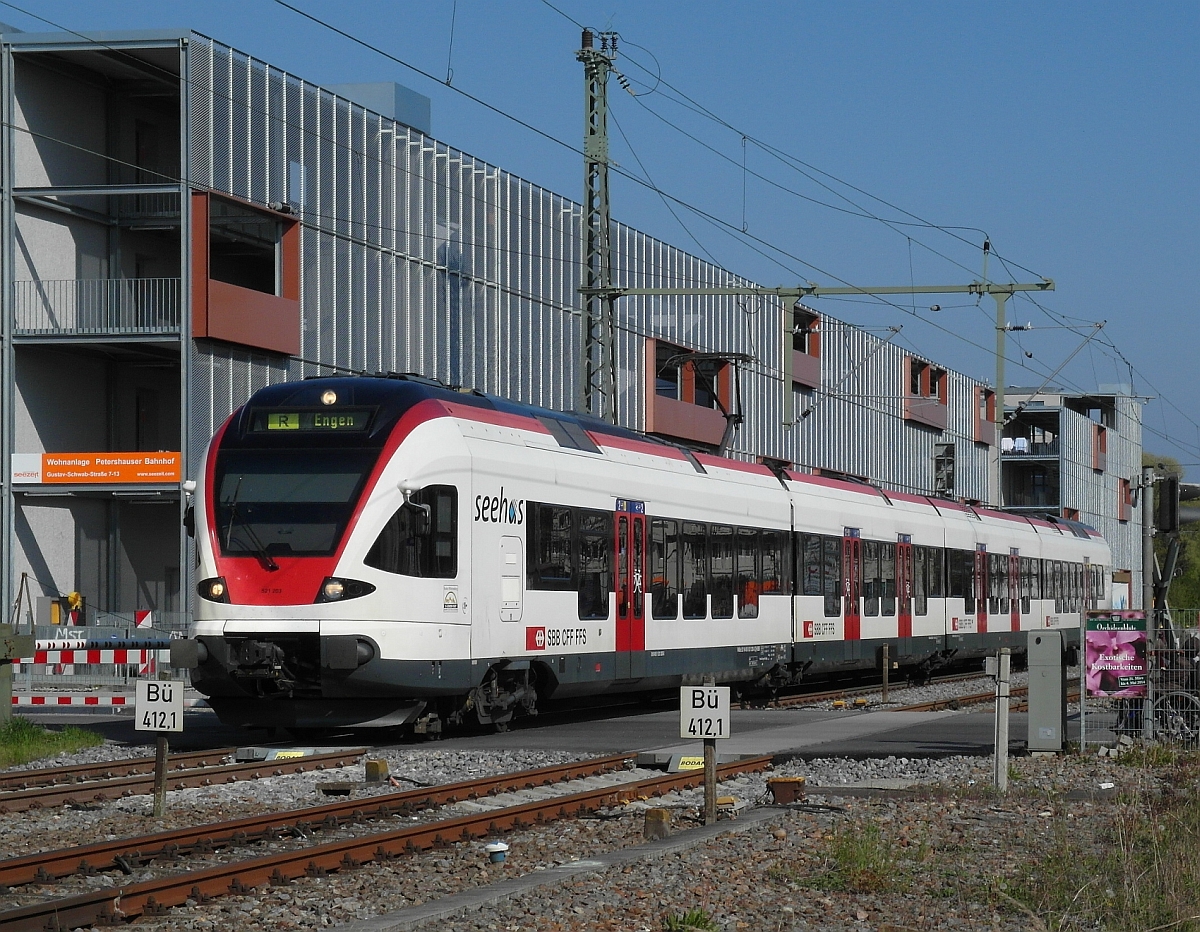 Die Fassade des aussenstehenden 'Treppenhauses' einer Wohnanlage als Hintergrundmotiv für den Stadler-FLIRT, der als SBB 87700 von Konstanz nach Engen fährt (Konstanz-Petershausen, 20.04.2014).
