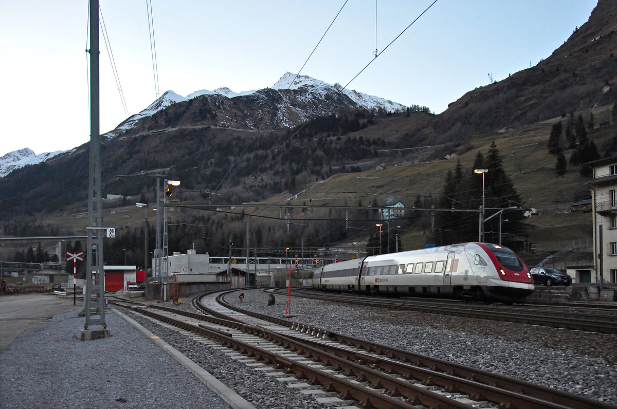 Die fehlende Sonne machte sich langsam durch Kälte bemerkbar, als ein ICN am 07.12.2016 aus dem alten Gotthardtunnel durch Airolo fuhr. Im Hintergrund das Gotthardmassiv. 