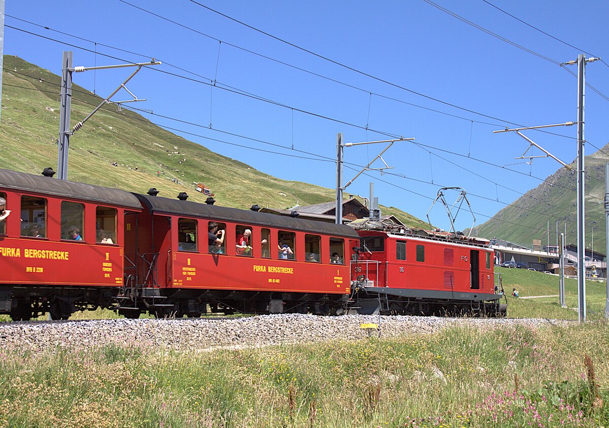 Die FO 36, �ber 80 Jahre alt, zieht am 04.07.2026 den Jubil�umszug, im Rahmen der Feierlichkeiten zu 100 Jahre Furka-Oberalp-Bahn, von Andermatt her zum Oberalppass. Aufgenommen habe ich das Bild in der Station N�tschen.
Die im Zug verwendeten Wagen geh�ren der DFB.
Jahrzehntelang zogen diese Lokomotiven den langsamsten Schnellzug der Welt, den Glacier-Express. In der langen Zeit wurde daf�r verschiedenstes Wagenmaterial verwendet.  