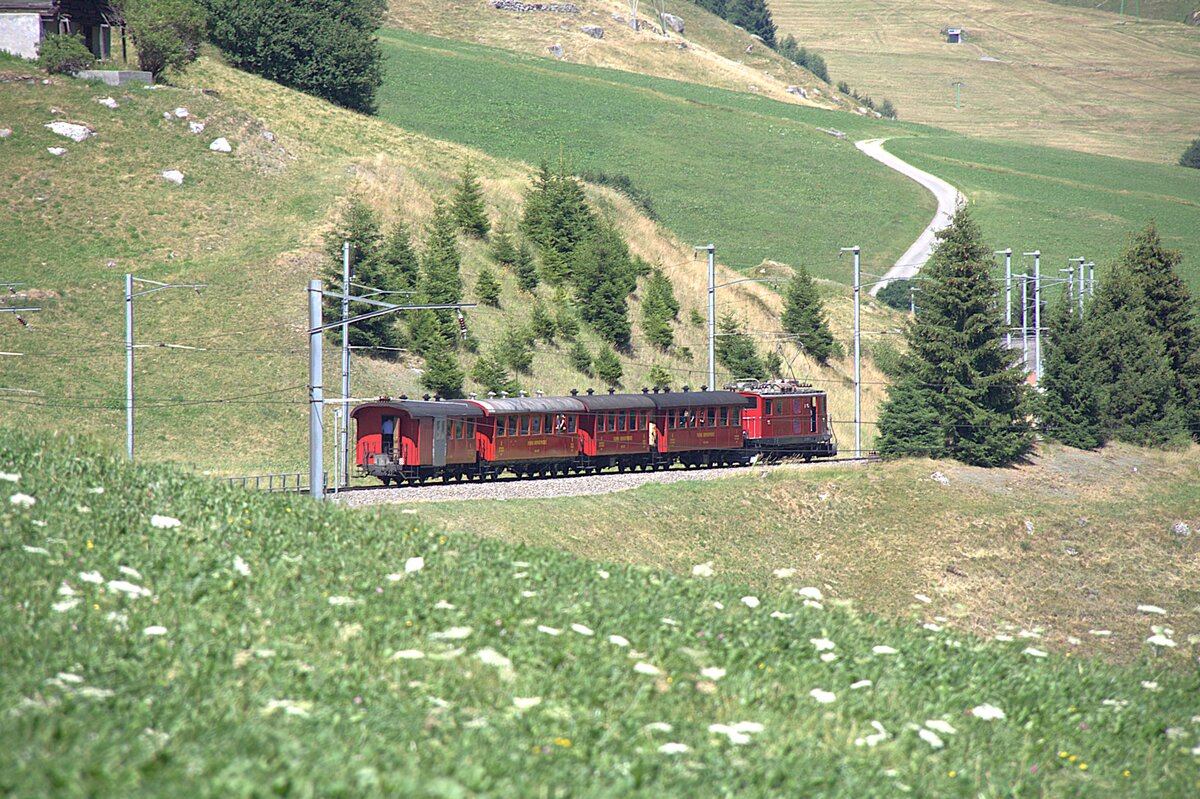 Die FO 36, �ber 80 Jahre alt, zieht am 04.07.2026 den Jubil�umszug, im Rahmen der Feierlichkeiten zu 100 Jahre Furka-Oberalp-Bahn, vom Oberalppass her Richtung Diesentis. Aufgenommen habe ich das Bild kurz vor Rueras.
Die im Zug verwendeten Wagen geh�ren der DFB.
Jahrzehntelang zogen diese Lokomotiven den langsamsten Schnellzug der Welt, den Glacier-Express.  