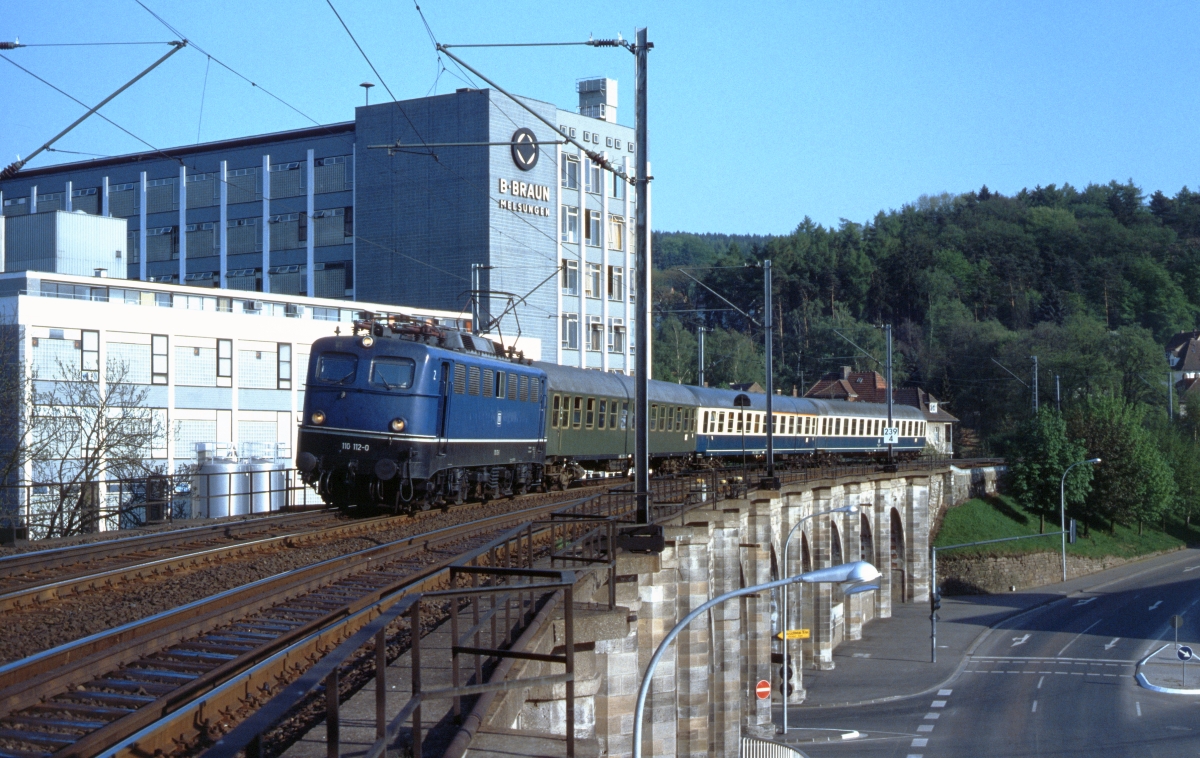 Die Frankfurter 110 112 mit einem Eilzug in Richtung Kassel auf dem Stadtviadukt in Melsungen im Sommer 1979.
