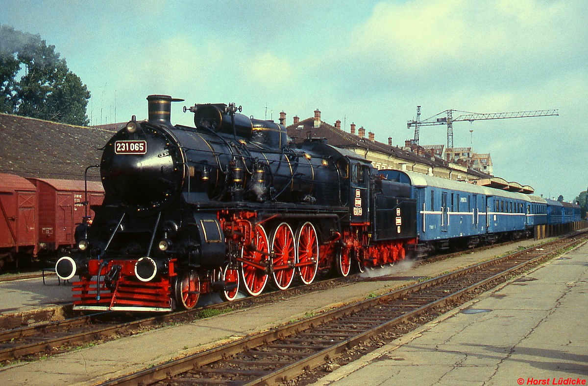 Die frisch hauptuntersuchte 231.065 steht im Juli 1995 mit einem Sonderzug abfahrbereit im Bahnhof Sibiu/Hermannstadt. Das Äußere verrät, dass die 2'C1'h4-Maschine auf eine Konstruktion aus dem Hause Maffei zurückgeht, die 231.065 wurde allerdings von Henschel 1922 (Fabrik-Nr. 18999) gebaut.