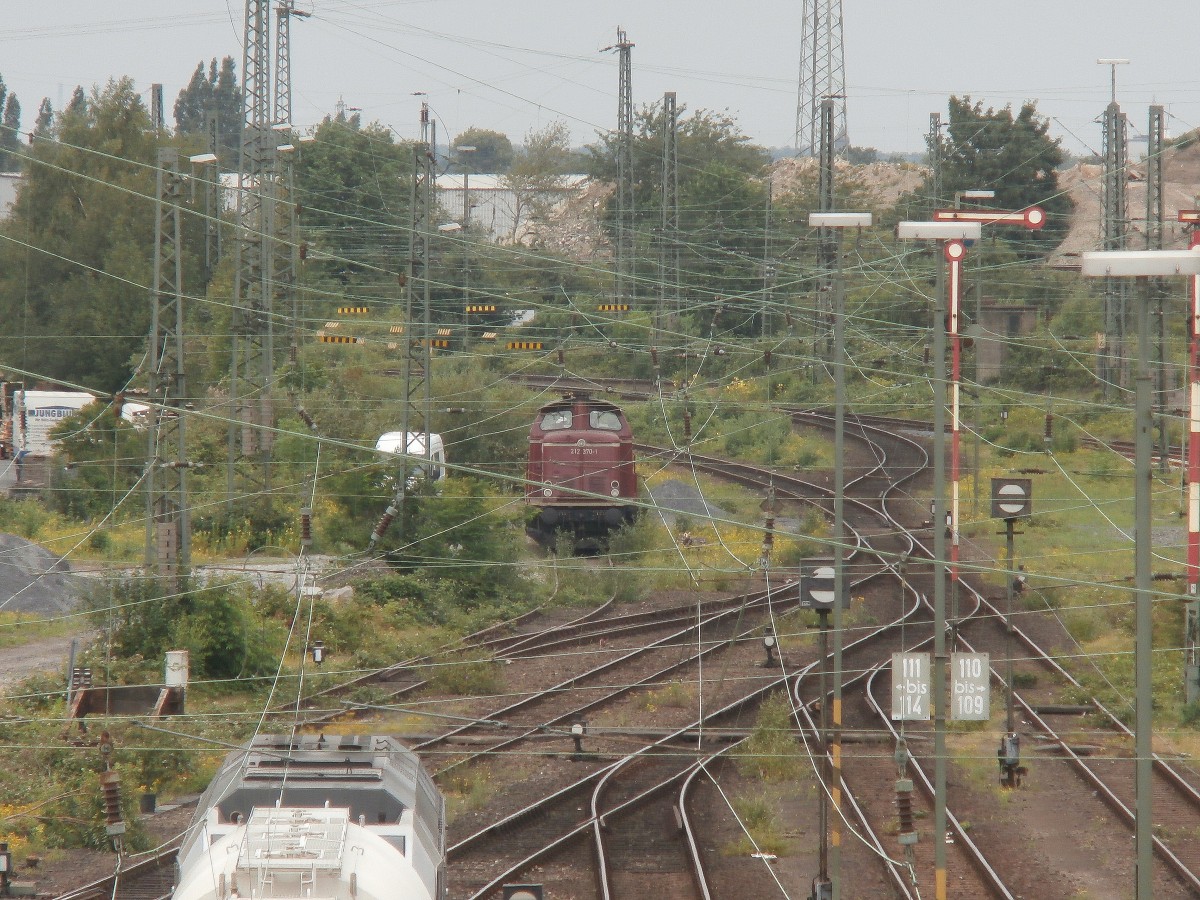 Die Front der 212 370-1 durch die etlichen Drähte der Oberleitungen gesehen.
Abgelichtet von der Fesser Straße über den Güterbahnhof.
Neuss 19.06.2014