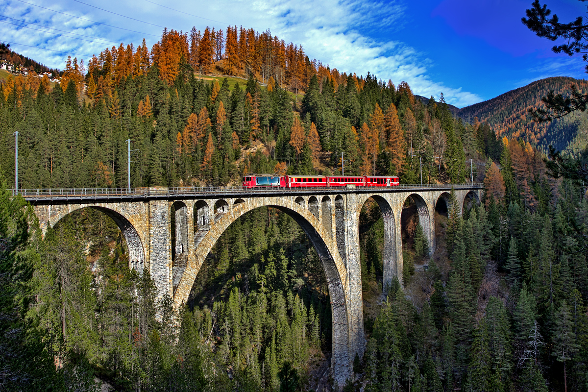 Die Ge 4/4 II 617  Ilanz  fährt mit einem Re über das Wiesener Viadukt,dem zweithöchsten Viadukt der RhB mit 88.9 m Höhe und 210m Länge.Bild vom 13.11.2015