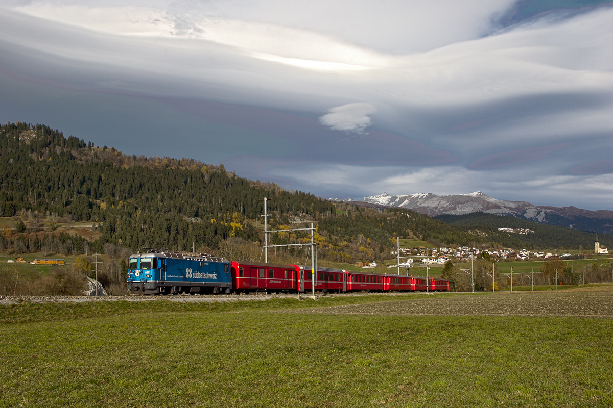 Die Ge 4/4 II 619  Samedan  fährt bei einer stark ausgeprägten Föhnstimmung mit dem RE von Chur nach Disentis in Castrisch vorüber.Bild vom 4.11.2015