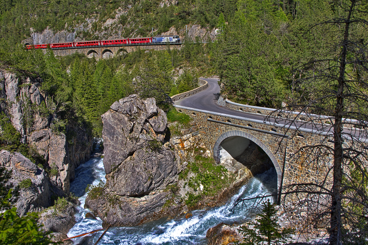 Die Ge 4/4 III 649 fährt mit einem Re von Chur nach St.Moritz durch die Kehr-und Spiraltunnels in Preda,der Fluss Albula führt noch immer Hochwasser.Bild vom 23.6.2016