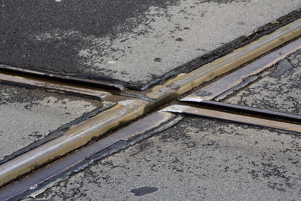 Die Gleise der Strecke Olomouc – Drahanovice (KBS 275) werden im Stadtgebiet von Olmütz mehrfach von der Straßenbahn gekreuzt. Dabei sind die Schienen der Vollbahn durchgehend und die der Straßenbahn unterbrochen, so dass die Straßenbahn die Vollbahnschiene auf den Spurkränzen überfährt. Das Bild vom 06.April 2019 zeigt ein Detail der Kreuzung der Straßenbahngleise mit der CD-Strecke Olomouc – Drahanovice in der Wolkerova beim Bahnhof Olomouc Nova Ulice.