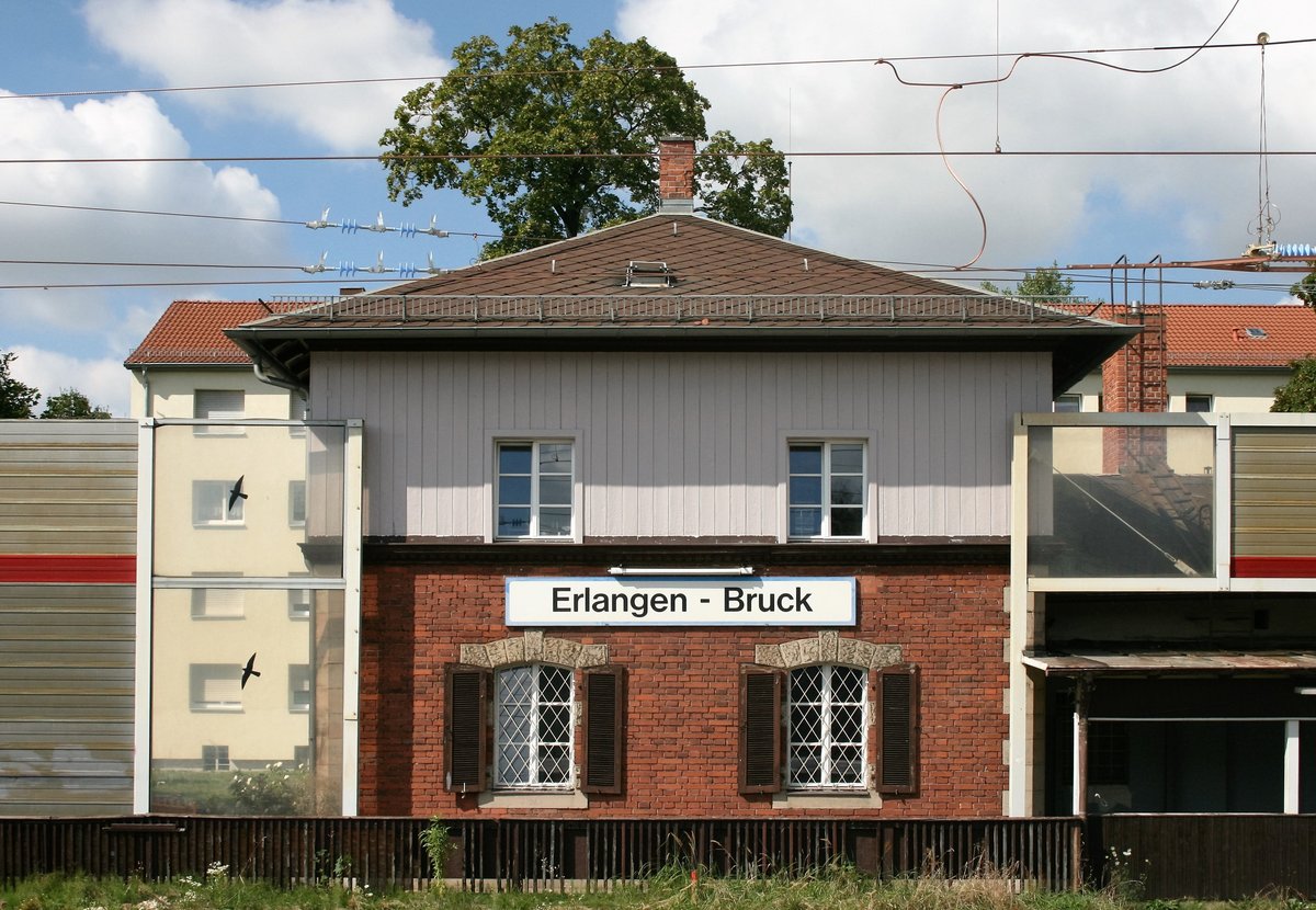 Die Gleisseite des Empfangsgebäudes von Erlangen-Bruck am 06.09.2016; man beachte die beim viergleisigen Streckenausbau errichteten Lärmschutzwände, die kaum zur Verschönerung des Ensembles beitragen.