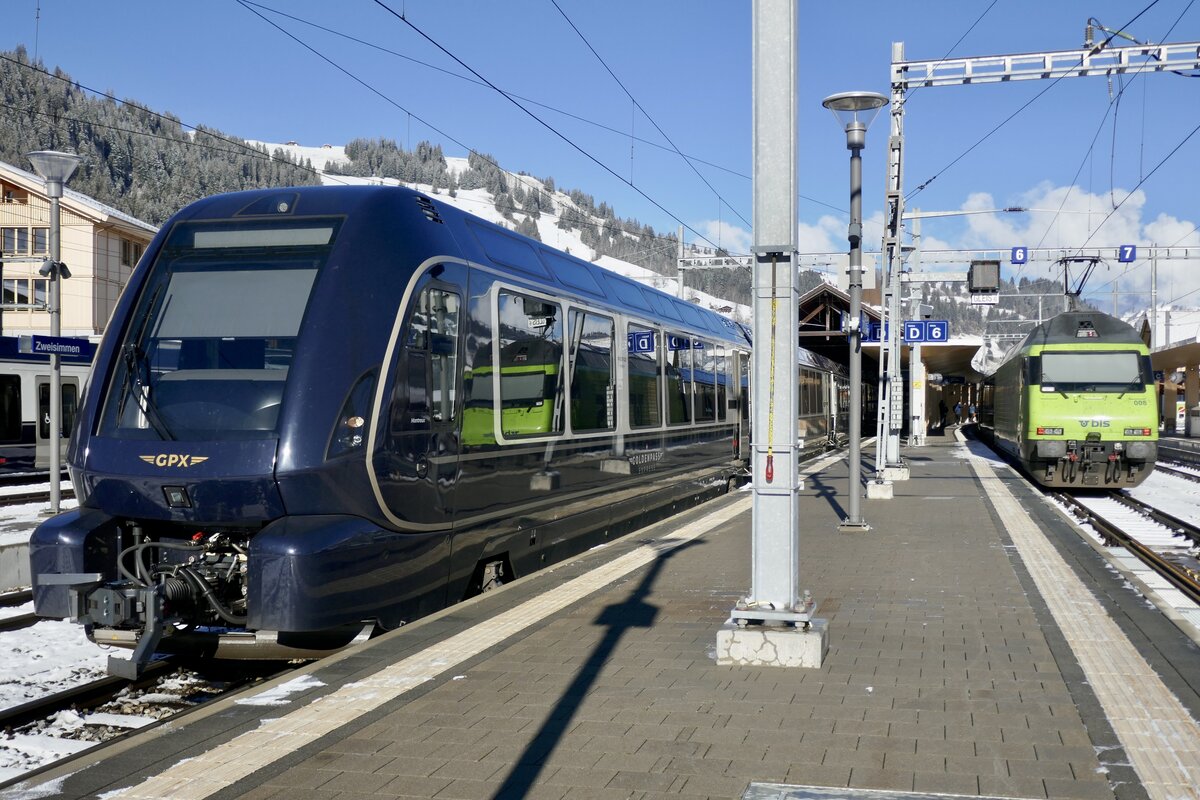 Die GPX Komp 1  Montreux  der hier endet und die Re 465 008 mit der Komp 4  Shania Train  auf den umgestiegen wurde um weiter nach Interlaken zu fahren am 26.11.23 im Bahnhof Zwesimmen.