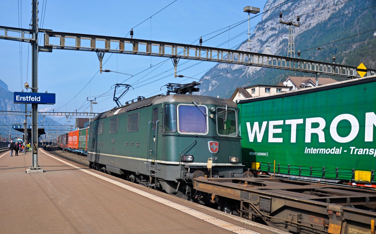 Die grüne Re 4/4 II 11330 ist am 20.03.2015 im Schiebedienst eingeteilt und verlässt soeben Erstfeld um einen weiteren Güterzug den Gotthard hinauf bis nach Göschenen zu unterstützen. 