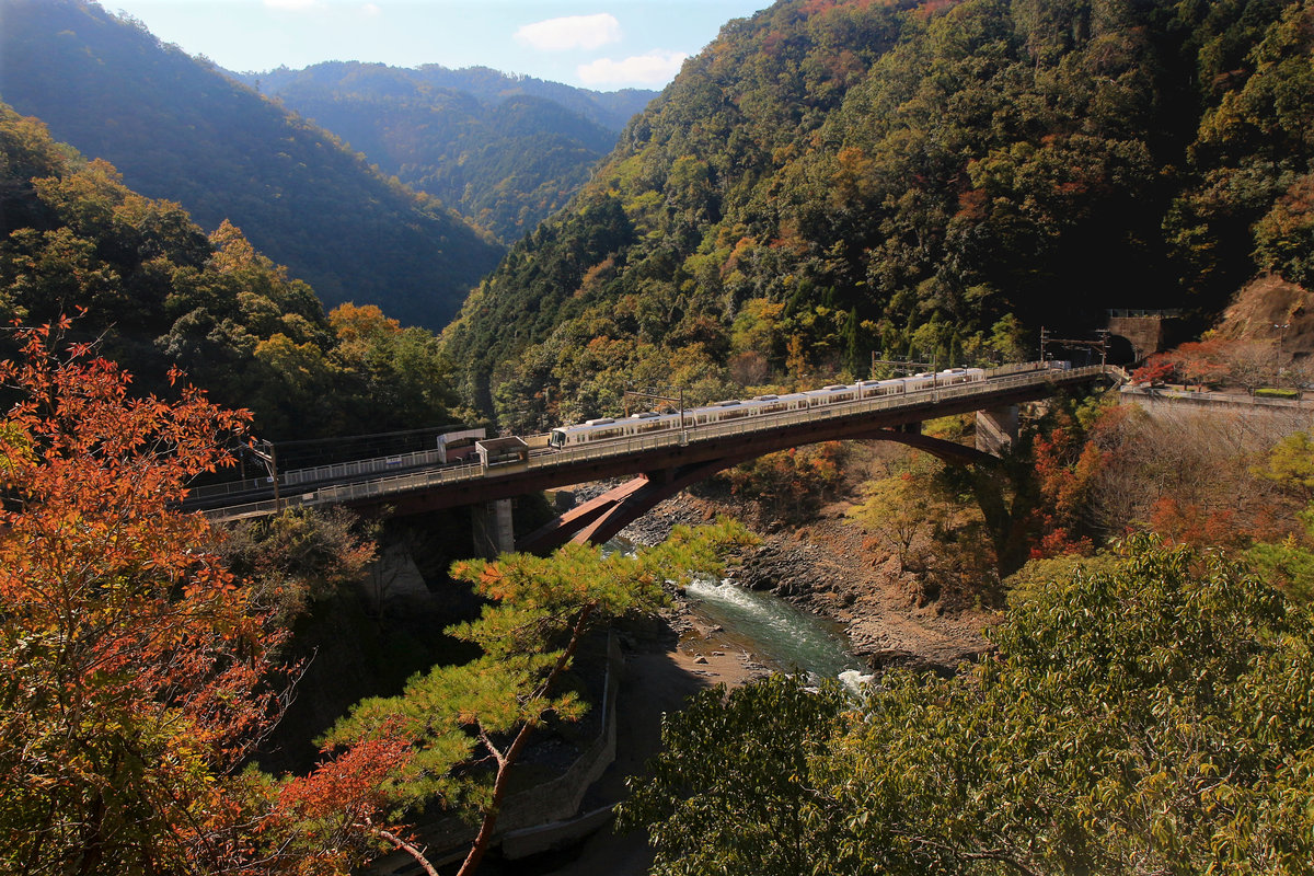 Die Haltestelle Hozukyô an der Strecke von Kyôto ins Hinterland. Ein S-Bahnzug Serie 221 fährt tief ins Gebirge Richtung Japanisches Meer. 8.November 2018 