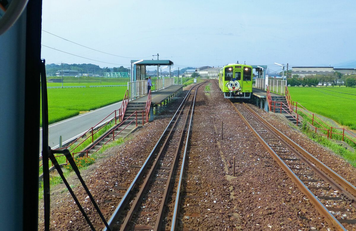 Die Heisei Chikuhô Bahn: Hier im westlichen Teil der Strecke besteht noch die Doppelspur aus der Zeit der ununterbrochenen Folge schwerer Kohlezüge. Triebwagen 411 steht inmitten sommerlich grüner Reisfelder in der Haltestelle Akaji, 25.Juli 2013 