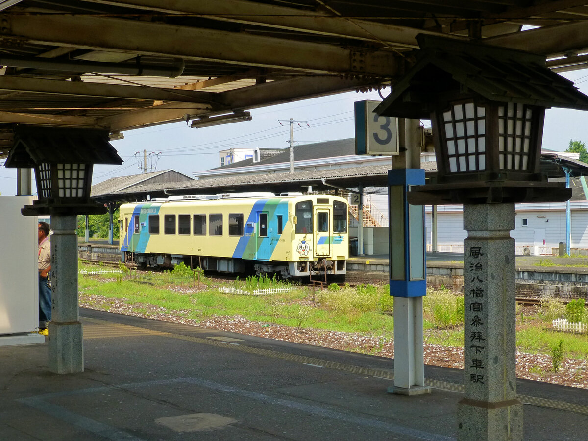 Die Heisei Chikuhô Bahn: In der Mitte zwischen dem Westteil und dem Ostteil der Strecke wartet Triebwagen 402 in Tagawa Ita. Wo einst reger Güterverkehr herrschte ist jetzt alles fast regungslos ruhig, auf der grossen Laterne steht  Hier aussteigen zum Fuji Hachiman-gû Schrein , zum Schrein also der Gottheit Hachiman, der die Winde in Ordnung bringt und beruhigt . 27.Juli 2013  
