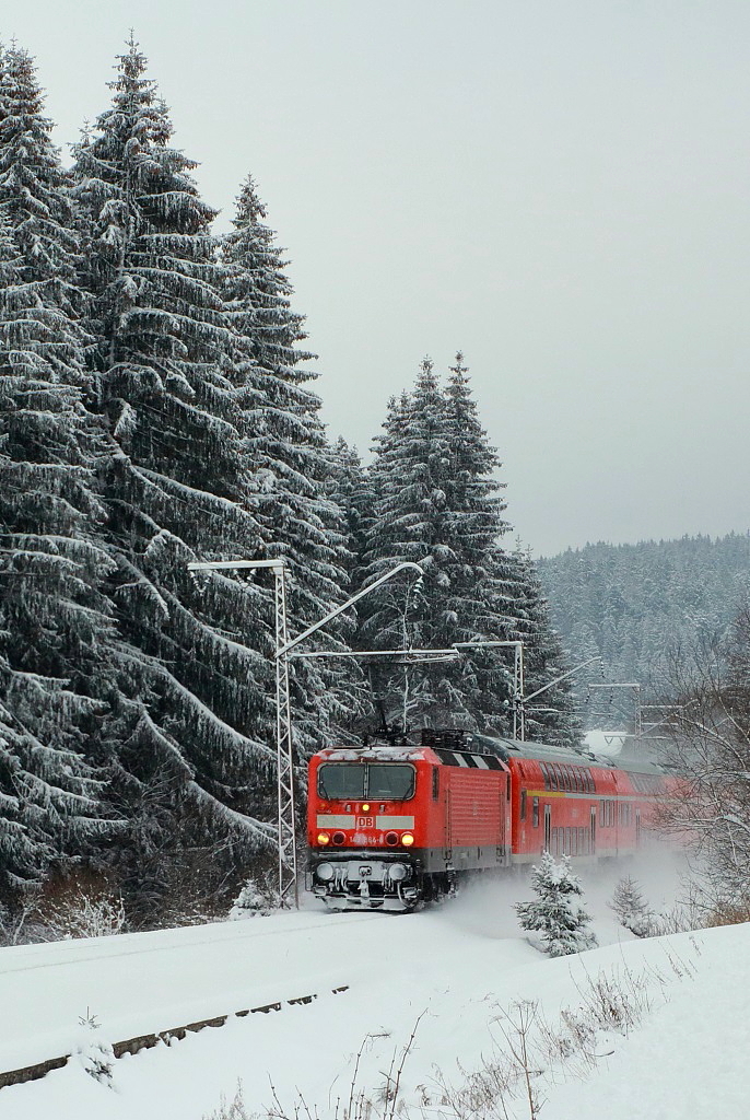 Die Höllentalbahn im Winter: Mit einem Regionalexpress nach Freiburg fährt eine unbekannte 143 am 28.12.2014 von Titisee nach Hinterzarten. Wie zierlich Lok und Wagen doch im Vergleich zu den mächtigen Tannen wirken...