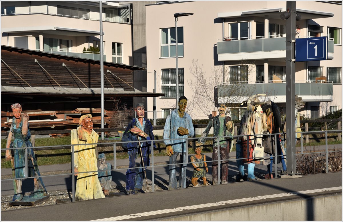 Die hölzernen Reisenden am Bahnhof Malans, von einem örtlichen Künstler erstellt. (06.12.2019)