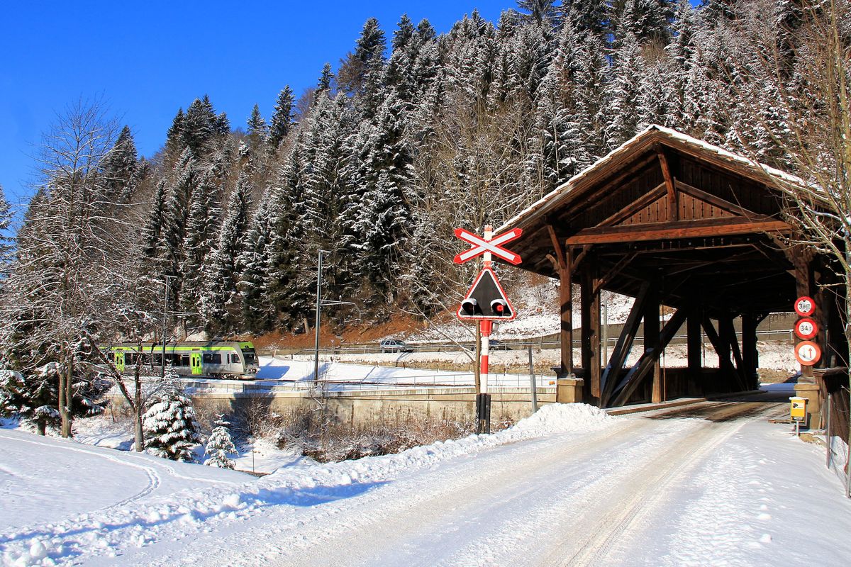 Die Holzbrücke bei Trubschachen von der Südseite her mit dem Warnkreuz vor der Brückeneinfahrt. Im Hintergrund BLS  Lötschberger  123 als Schnellzug nach Luzern. 6.Januar 2017. 